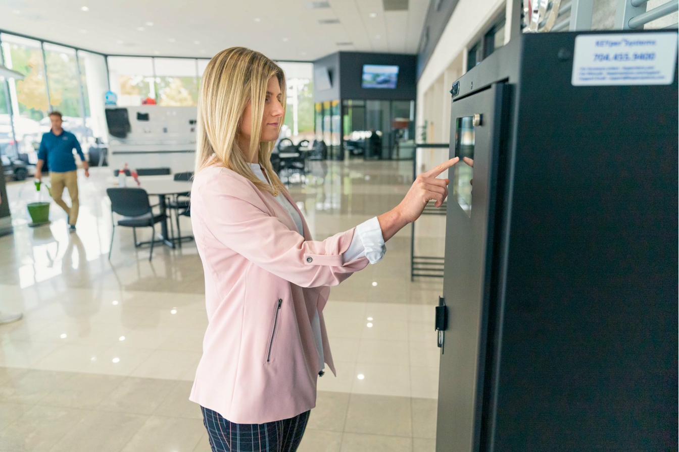 Autohaus-Mitarbeiterin bedient den KEYper-Touchscreen in der Servicewerkstatt